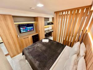 a room with a bed and a television in it at Cabo Branco - Legacy Suítes in João Pessoa