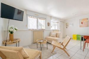 a living room with a couch and a flat screen tv at Cocon Studio proche Disneyland in Lagny