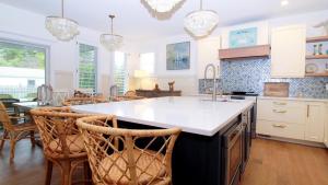a kitchen with a large island with bar chairs at Beach Croft in West Cape May