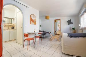 a kitchen and a living room with a table and chairs at Cocon Studio proche Disneyland in Lagny