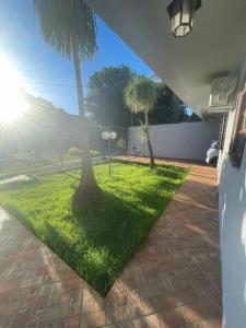 a grassy yard with two palm trees and the sun at Lareconexao in Foz do Iguaçu