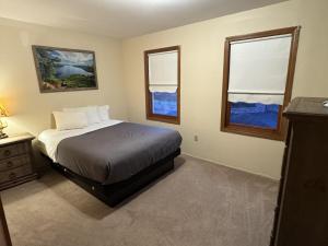 a bedroom with a bed and two windows at Studio 6 Lake George NY Adirondacks in Lake George +34 photos