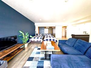 a living room with a blue couch and a table at Blu Mare in Ō-shima