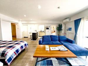 a living room with a blue couch and a bed at Blu Mare in Ō-shima