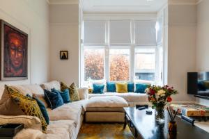 a living room with a couch and a large window at Beautiful 5 Bedroom Home in Evesham in Evesham