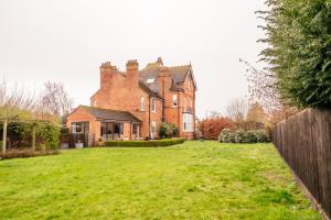 an old brick house with a yard in front of it at Beautiful 5 Bedroom Home in Evesham in Evesham