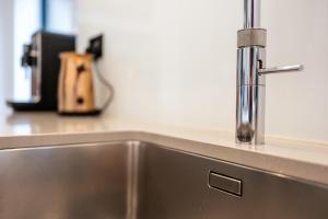 a kitchen sink with a faucet on a counter at Beautiful 5 Bedroom Home in Evesham in Evesham +145 photos