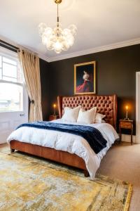 a bedroom with a large bed and a chandelier at Beautiful 5 Bedroom Home in Evesham in Evesham