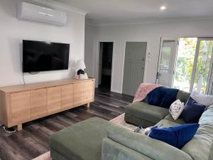 a living room with a couch and a flat screen tv at Hathaway House in Toowoomba