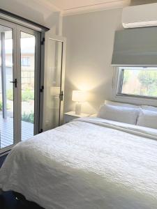 a bedroom with a white bed and a window at Hathaway House in Toowoomba