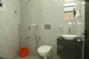 a bathroom with a toilet and a sink at Kalathil Kshetra Inn in Guruvāyūr