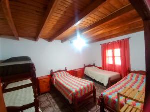 a bedroom with two beds and a window and a ceiling at Hostal Nahiara, Iruya in Iruya