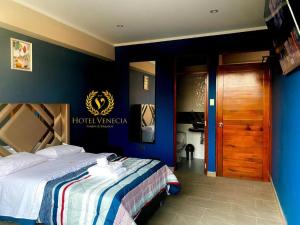 a hotel room with a bed and a sign on the wall at Hotel Venecia ll in Huánuco