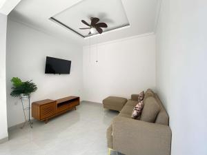 a living room with a couch and a ceiling fan at Villa Sinyo By Mentaripro Bali in Lovina