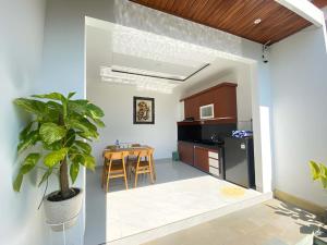 a kitchen and dining room with a potted plant at Villa Sinyo By Mentaripro Bali in Lovina