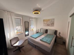 a bedroom with a bed and a chair in it at Doppelzimmer mit Ausblick in Nürtingen