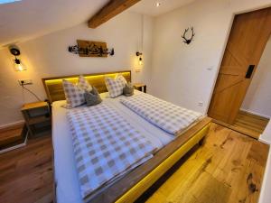 a large bed in a room with a wooden floor at Ferienwohnungen Hörterer | Chiemgau Karte in Grassau