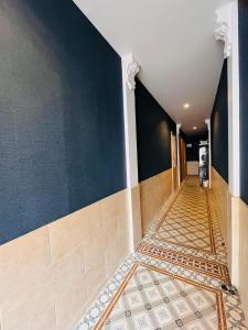 a hallway with a blue wall and a tile floor at Chambre à soulac in Soulac-sur-Mer