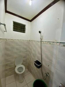 a bathroom with a toilet and a shower at Hibiscus Dive Inn in Pooc