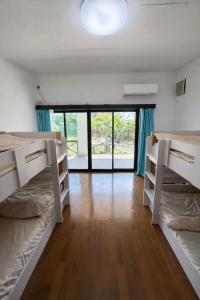 a room with two bunk beds and a large window at Lagoon藍yoron 一棟貸し in Yoron