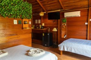 a room with wooden walls and two beds and a kitchen at Cabañas SyC in Fortuna +220 photos