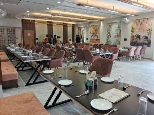 a conference room with tables and chairs and people in the background at Hotel Shrivardhan in Sūratgarh