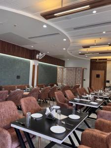 a conference room with tables and chairs and a screen at Hotel Shrivardhan in Sūratgarh