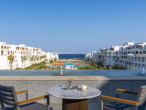 a table and chairs on a balcony with a view of the ocean at Rixos Radamis Sharm El Sheikh in Sharm El Sheikh