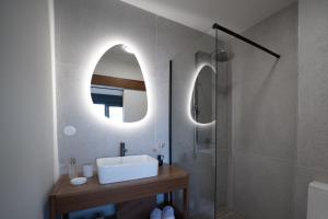 a bathroom with a sink and a mirror at Maison Le Patio Jacuzzi in Saint-Denis