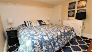 a bedroom with a bed with a blue and white blanket at Heritage House 2 in Cape May