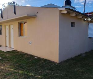 a white building with a window and a door at Tomás in Mar de Ajó