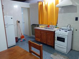 a kitchen with a white stove and a sink at Tomás in Mar de Ajó