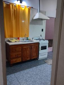 a kitchen with a sink and a stove at Tomás in Mar de Ajó +1 photo