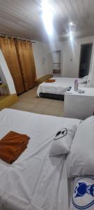 a large room with two beds and a table with towels at Depa más pileta en Ypane in Ypane +10 photos