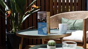 a table with a book and a coffee cup on it at Maison Le Patio Jacuzzi in Saint-Denis