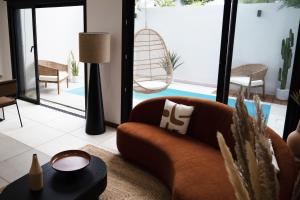 a living room with a couch and a chair at Maison Le Patio Jacuzzi in Saint-Denis +7 photos