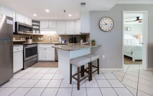 a kitchen with white cabinets and a counter with stools at Phoenix III 3126 in Orange Beach