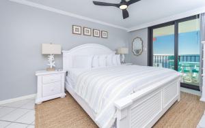 a white bedroom with a white bed and a window at Phoenix III 3126 in Orange Beach +48 photos