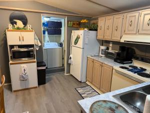 a kitchen with white appliances and wooden cabinets at The Revival Retreat in Gloucester