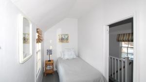 a white bedroom with a bed and a window at The Elmira Escape in Cape May