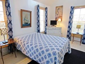 a bedroom with a bed with a blue and white comforter at The Elmira Escape in Cape May +4 photos