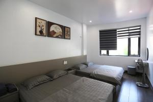 a bedroom with two beds and a window at VITA Homestay in Cat Ba