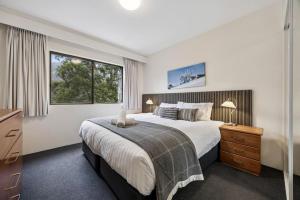 a bedroom with a large bed and a window at Lantern 05 - Balcony in Thredbo +14 photos