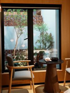 a table and a chair in front of a window at a1 Art Hotel in Quanzhou