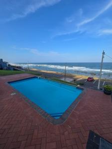 a swimming pool with the ocean in the background at Umdloti Luxe Horizon in Umdloti