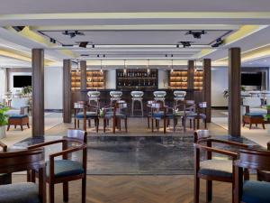 a restaurant with a bar with wooden tables and chairs at Mövenpick Royal Lily Nile Cruise, Every Monday Four Nights From Luxor, Every Friday Three Nights From Aswan in Luxor