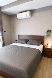 a bedroom with a large bed with a white bedsheet at Muay Thai Apartment - Ratchada in Bangkok +53 photos