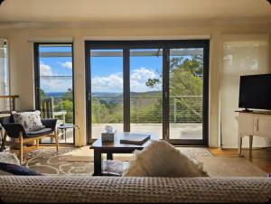 a living room with a couch and a large window at Narrow Neck Views - Peaceful 4 Bedroom Home with Stunning Views! in Katoomba