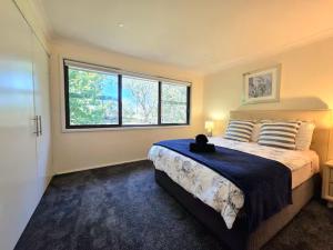 a bedroom with a large bed and a window at Narrow Neck Views - Peaceful 4 Bedroom Home with Stunning Views! in Katoomba