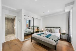 a bedroom with a large bed and a walk in shower at Queensview168 Apartments Moonee Ponds in Melbourne